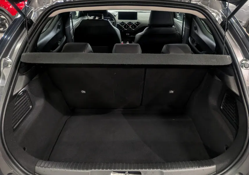 Coffre ouvert vu de l'arrière d'un DS3 Crossback gris Platinium avec intérieur noir et tablette cache-bagages.