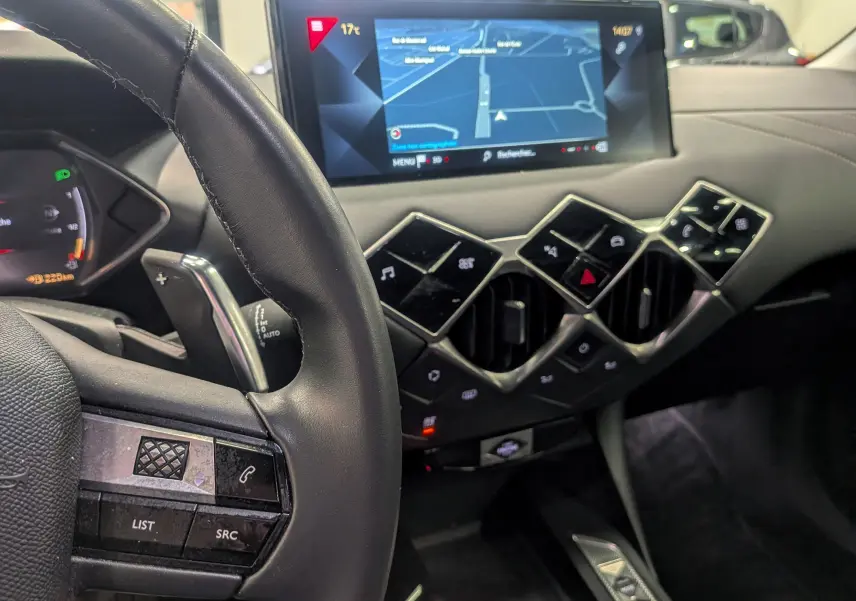 Vue rapprochée de l'intérieur du DS3 Crossback 2022, tableau de bord noir avec écran tactile et commandes géométriques.