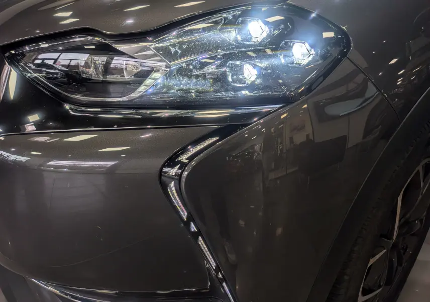 Gros plan sur le phare avant droit du DS3 Crossback gris Platinium avec toit noir, soulignant ses LED distinctives.