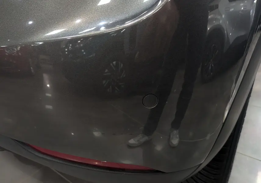 Gros plan sur le pare-chocs arrière gris Platinium du DS3 Crossback 2022 avec toit noir, montrant un capteur de stationnement.