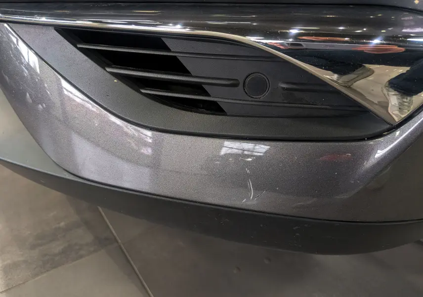 Gros plan sur la partie avant gauche gris Platinium du DS3 Crossback avec une grille noire et un capteur radar intégré.