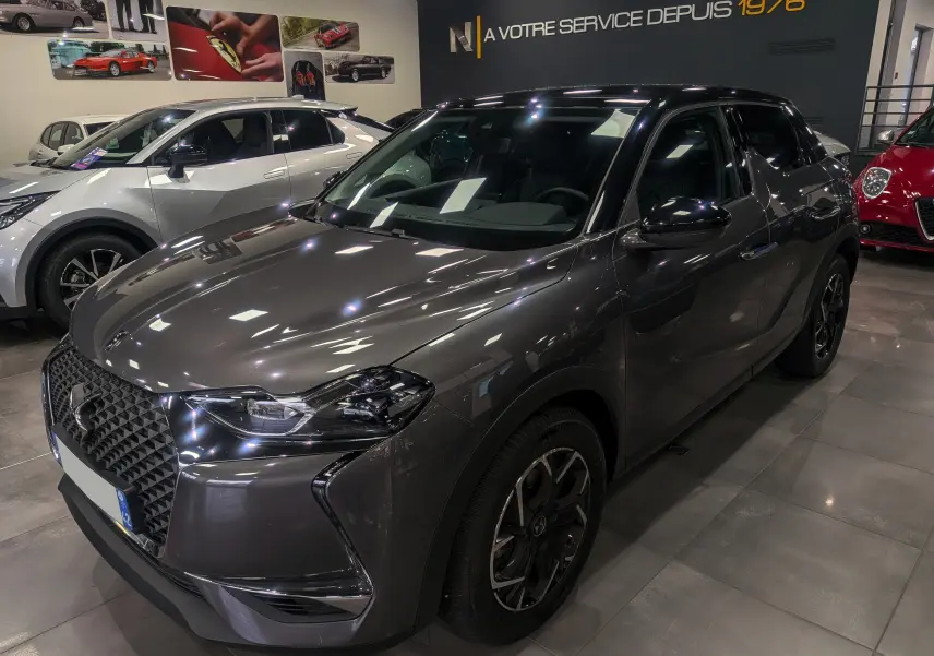 DS3 Crossback Diesel gris Platinium avec toit noir, vue 3/4 avant droit dans un showroom lumineux.