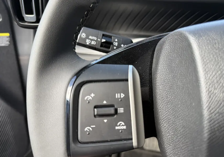 Gros plan sur les commandes de régulateur de vitesse au volant d'une Citroën C3 Aircross électrique gris Mercury avec toit noir.
