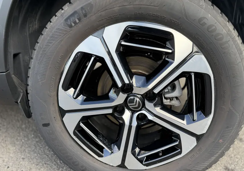 Gros plan sur la jante bi-ton noire et argentée d'une Citroën C3 Aircross électrique gris Mercury, pneu Goodyear visible.