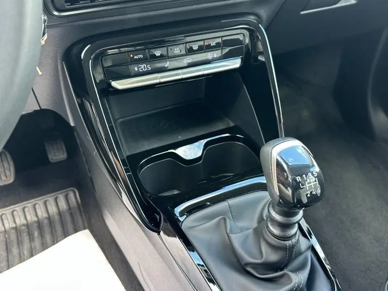 Gros plan sur la console centrale intérieure de la Citroën C3 2025 gris Mercury, avec levier de vitesses manuel et commandes climatisation.