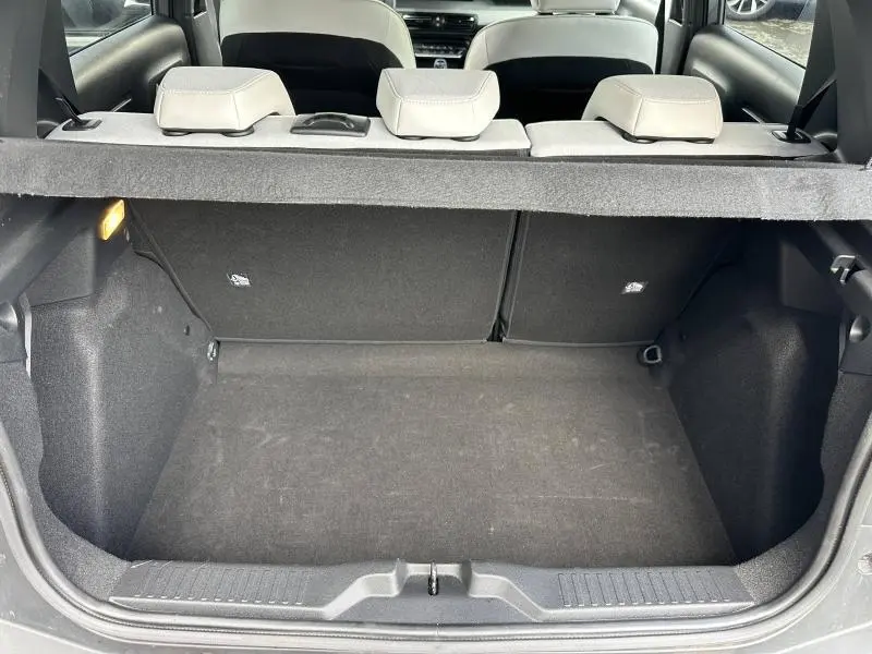 Coffre ouvert vu de l'arrière d'une Citroën C3 gris Mercury avec banquette arrière et cache-bagages visibles.