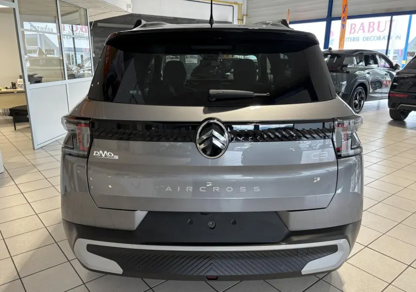 Vue arrière d'un Citroën C3 Aircross gris métallisé avec toit noir, feux arrière LED et logo central noir brillant.