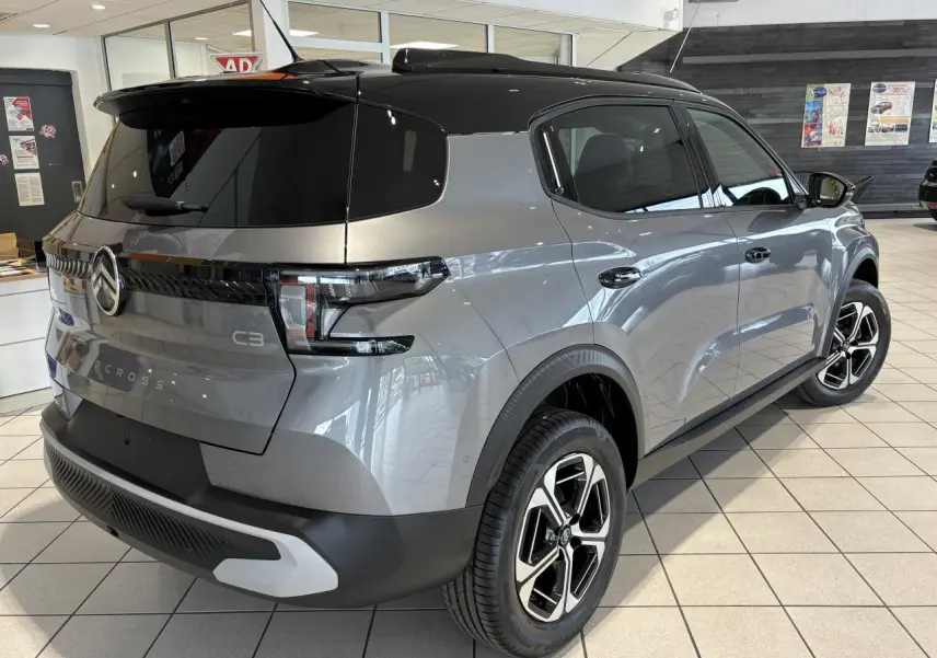 Vue 3/4 arrière droite du Citroën C3 Aircross 2026 gris métallisé avec toit noir et jantes alliage diamantées.