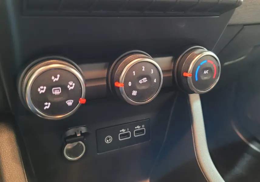 Gros plan sur les commandes de climatisation et ports USB d'une Renault Clio gris foncé, version Evolution Blue dCi 100 -25.