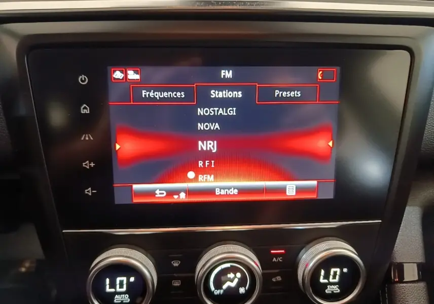 Écran tactile central du tableau de bord du Renault Kadjar gris foncé, affichant les stations radio FM.