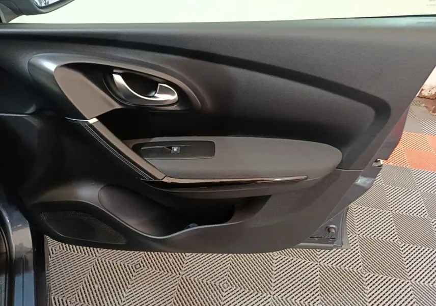 Vue rapprochée de la porte avant gauche gris foncé du Renault Kadjar 2021 avec poignée intérieure et commande de vitre.