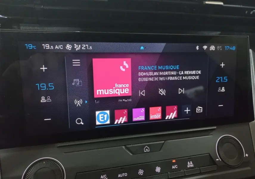 Écran tactile central de la Peugeot 308 PHEV 180 Allure 2025 affichant la radio et la climatisation.