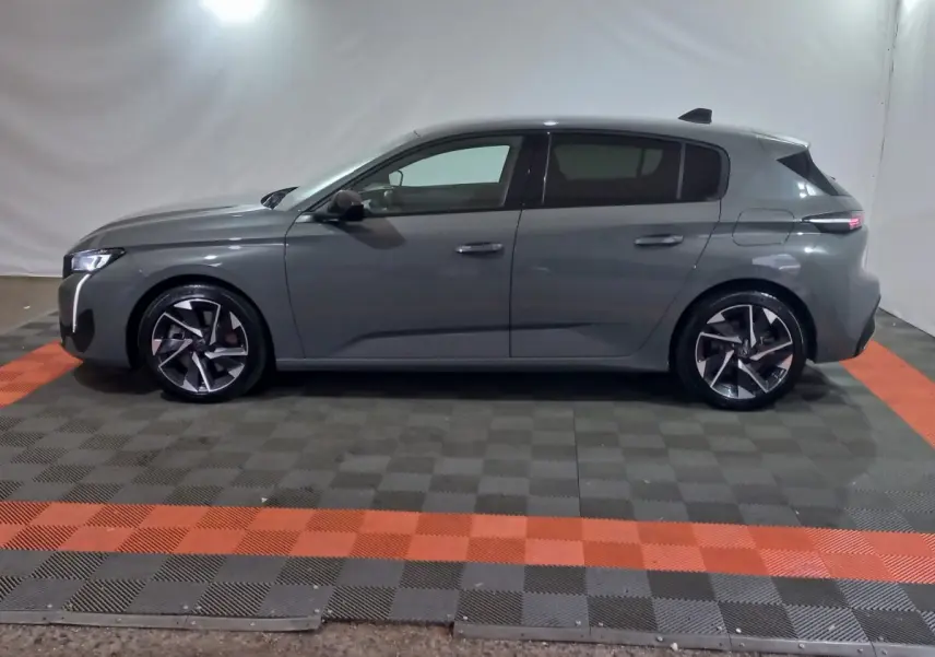 Peugeot 308 PHEV 180 gris foncé vue de profil côté gauche, avec jantes alliage et lignes modernes.