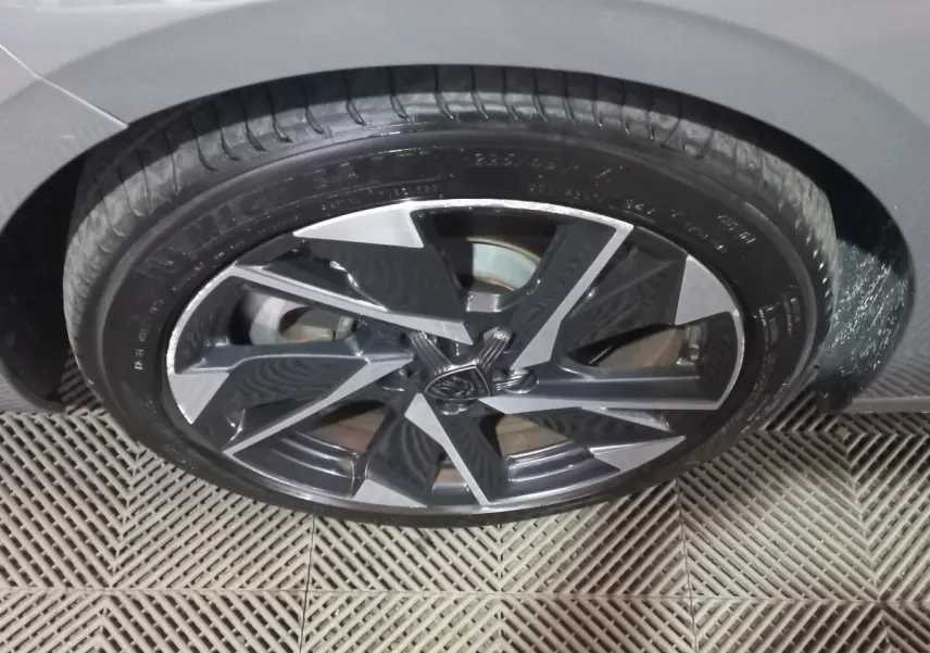 Gros plan sur la roue avant droite gris foncé de la Peugeot 308 PHEV 180 E-EAT8 Allure avec jante alliage moderne.