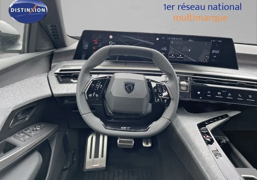 Intérieur du Peugeot 5008 Hybrid 2025, vue du poste de conduite avec volant GT et tableau de bord numérique large.