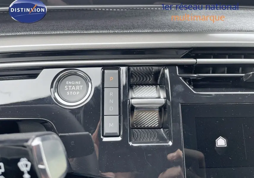 Gros plan sur la console centrale du Peugeot 5008 Hybrid 136ch GT 2025, avec bouton start/stop et commandes de boîte auto.