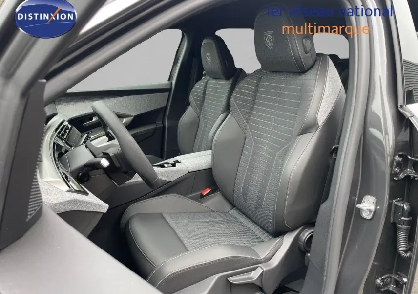 Vue intérieure côté conducteur du Peugeot 5008 gris titane, sièges en cuir noir et tissu gris avec logo Peugeot brodé.