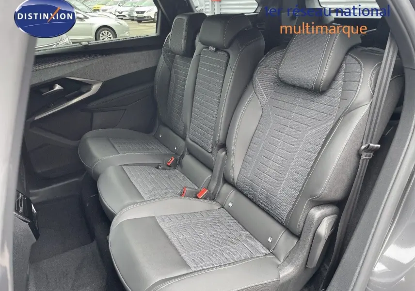 Vue latérale des sièges arrière en cuir noir et tissu gris du Peugeot 5008 Hybrid 2025, côté droit ouvert.