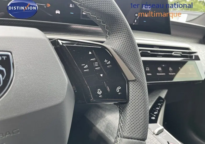 Gros plan sur le volant en cuir perforé gris avec commandes tactiles du Peugeot 5008 Hybrid 136ch GT 2025.