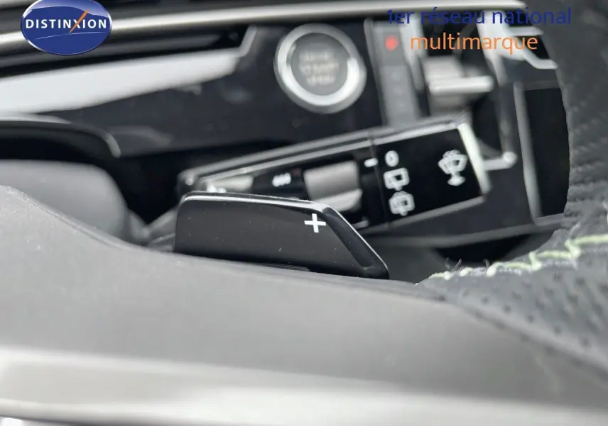 Gros plan sur la palette de changement de vitesse droite dans l'habitacle du Peugeot 5008 gris titane 2025 hybride.