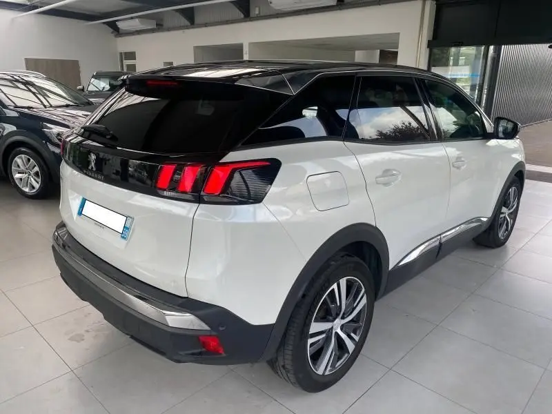 Peugeot 3008 blanc nacré vue 3/4 arrière droit avec toit noir et feux arrière LED distinctifs.