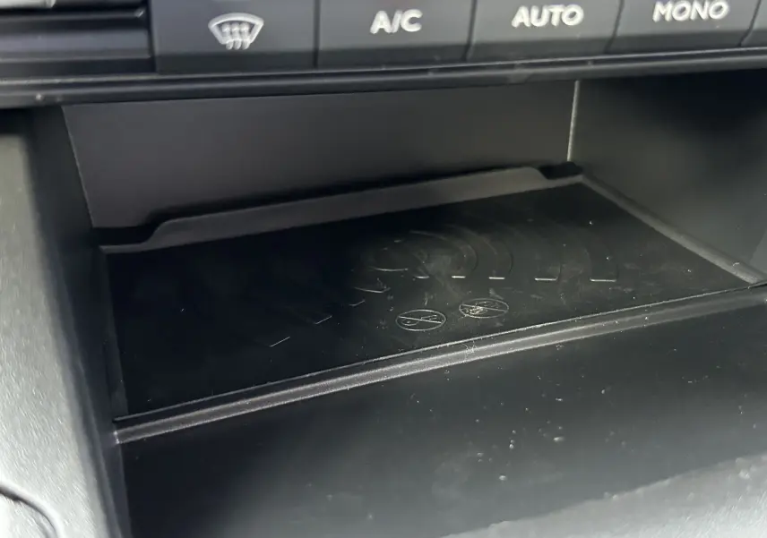 Détail du chargeur sans fil intégré sous la console centrale du Peugeot Partner Fourgon blanc 2025.