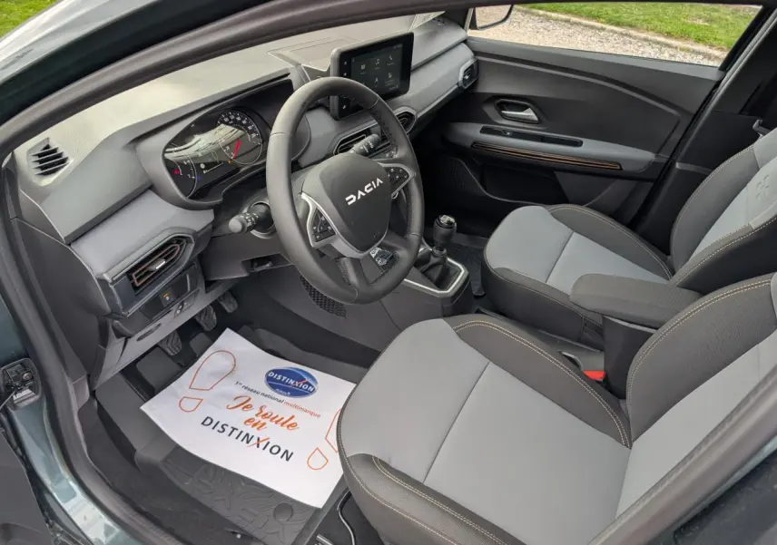 Intérieur avant droit du Dacia Jogger 2025 avec sellerie mixte gris et brun cuivré et tableau de bord moderne.