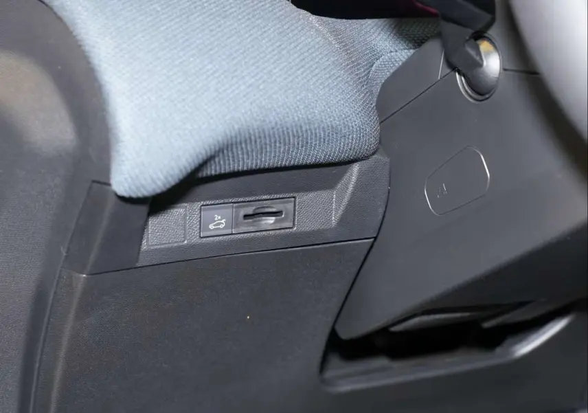 Détail intérieur côté gauche montrant le bouton d'ouverture du hayon sur le tableau de bord noir du Citroën C5 Aircross 2026.