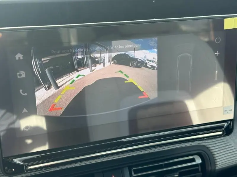 Écran tactile montrant la caméra de recul du Citroën C3 Aircross gris Mercury, vue arrière avec lignes de guidage colorées.