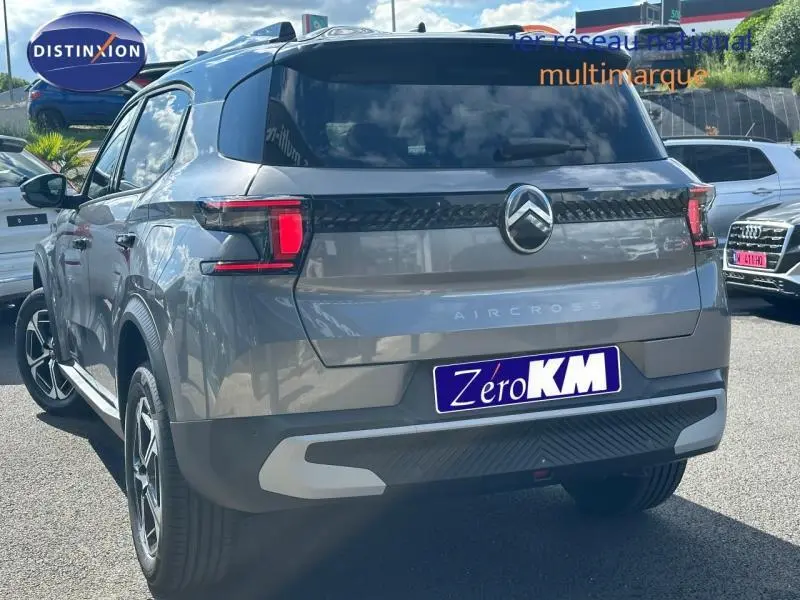 Vue 3/4 arrière droite d'un Citroën C3 Aircross gris Mercury avec feux arrière LED et logo chromé central.