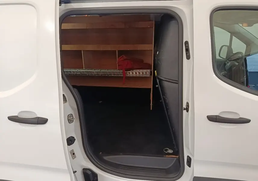 Vue latérale gauche d’un Citroën Berlingo blanc 2020 avec porte coulissante ouverte montrant l’espace de chargement aménagé.