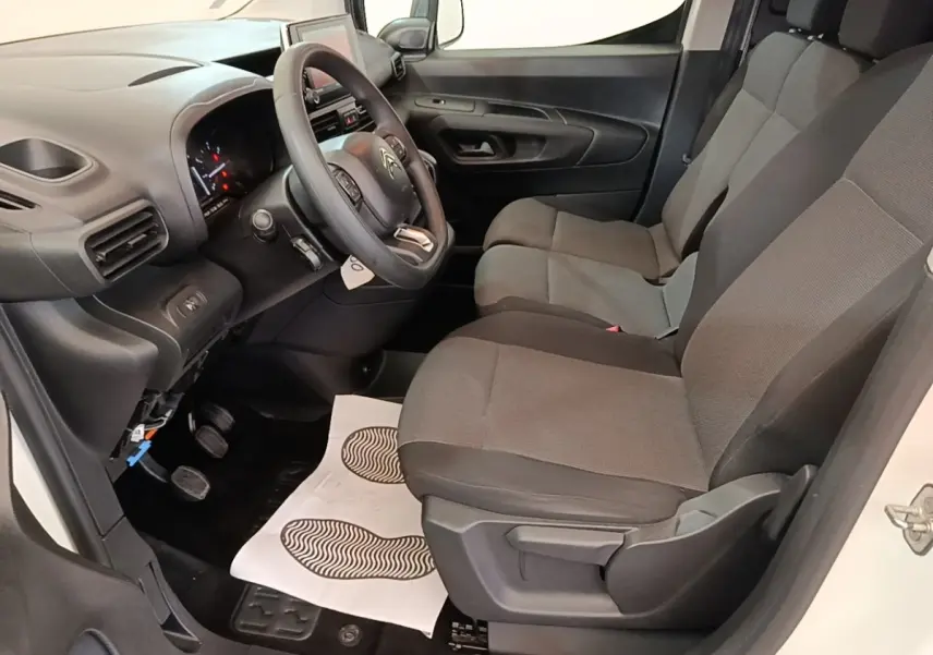 Vue intérieure côté conducteur du Citroën Berlingo blanc 2020, montrant les sièges et le tableau de bord moderne.