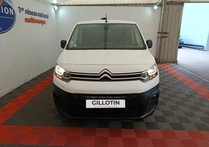 Vue frontale d'un Citroën Berlingo blanc avec phares allumés, calandre noire et plaque d'immatriculation GILLOTIN.
