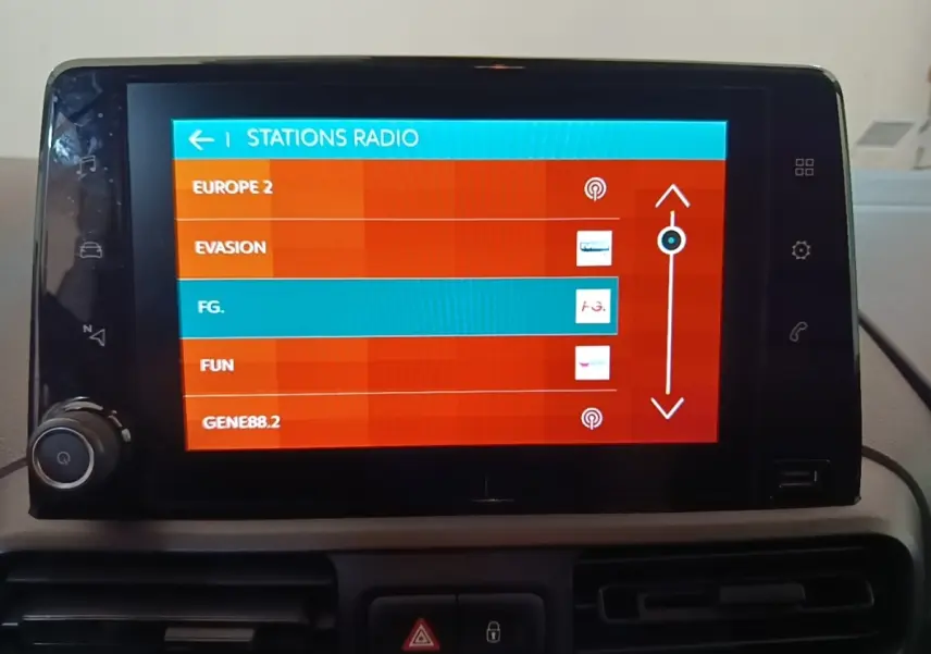 Écran tactile central de la Citroën Berlingo 2020 affichant la liste des stations radio en intérieur.