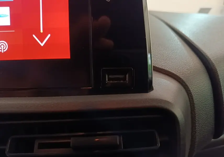 Gros plan sur l'écran tactile central noir et la prise USB du tableau de bord du Citroën Berlingo blanc de 2020.