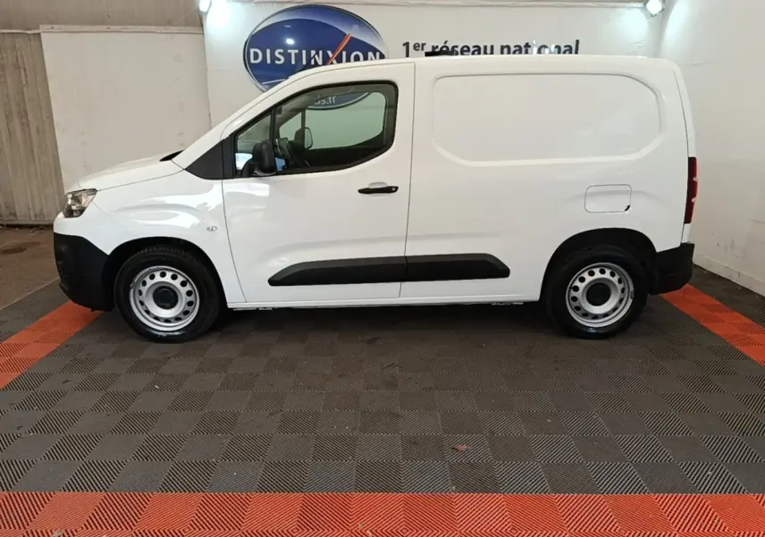 Vue de profil côté gauche d’un utilitaire Citroën Berlingo blanc avec porte latérale pleine et jantes acier.