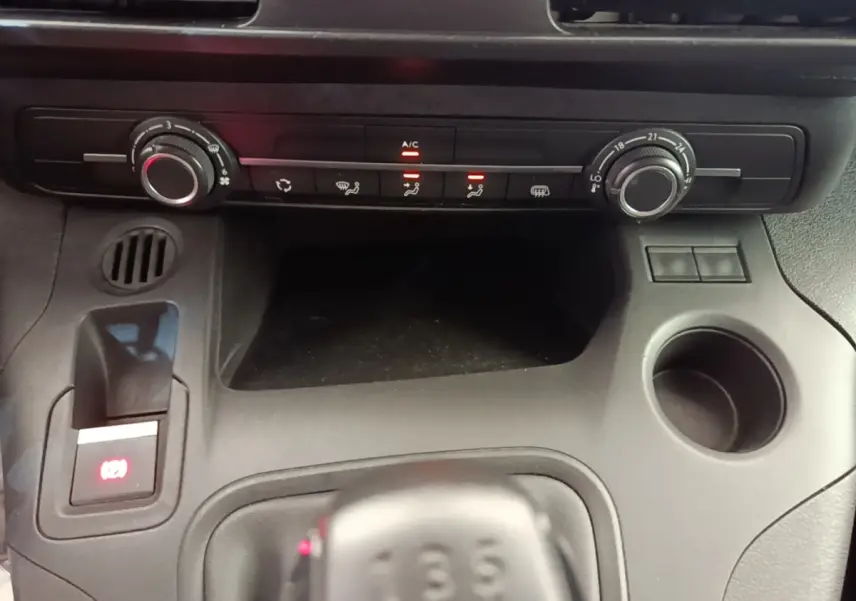 Vue rapprochée du tableau de bord noir du Citroën Berlingo 2020 avec commandes de climatisation et levier de vitesses manuel.