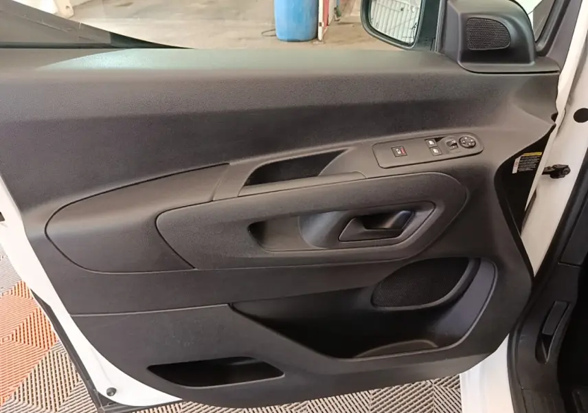 Vue intérieure côté gauche de la porte avant blanche du Citroën Berlingo 2020 avec commandes électriques et haut-parleur intégré.