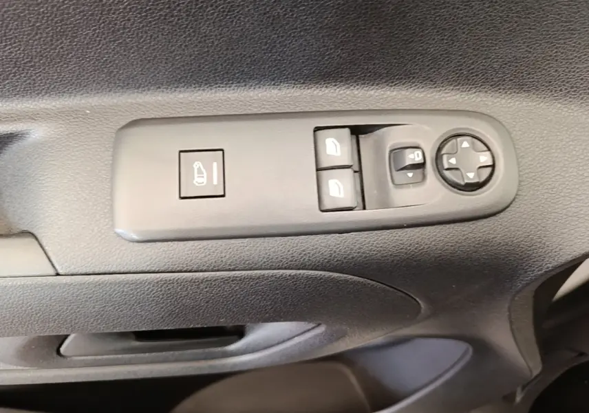 Gros plan sur les commandes de réglage des rétroviseurs et des vitres côté conducteur d’un Citroën Berlingo blanc.