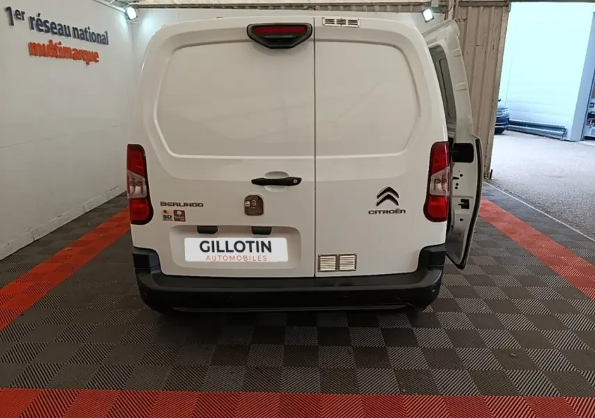 Vue arrière d’un Citroën Berlingo blanc 2020 avec porte arrière droite ouverte dans un garage.