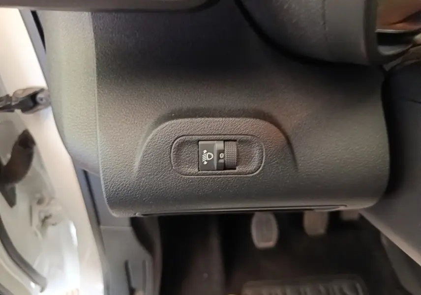 Gros plan sur le réglage manuel de hauteur des phares côté gauche dans un Citroën Berlingo blanc de 2020.