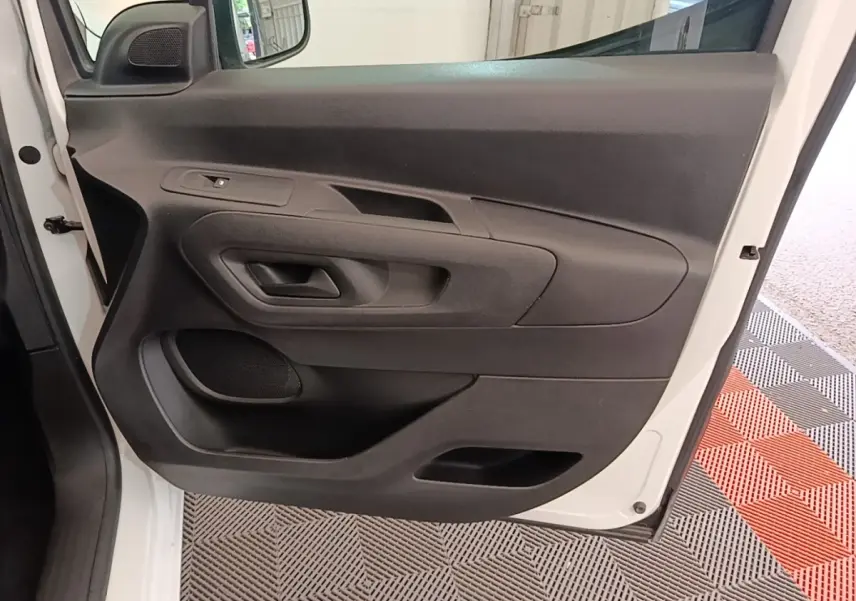 Vue rapprochée de la porte avant gauche blanche du Citroën Berlingo 2020 avec panneau intérieur noir.