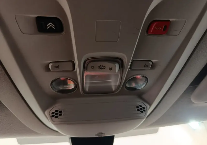 Plafonnier intérieur beige du Citroën Berlingo 2020 avec boutons d’éclairage, alarme SOS et haut-parleurs intégrés.