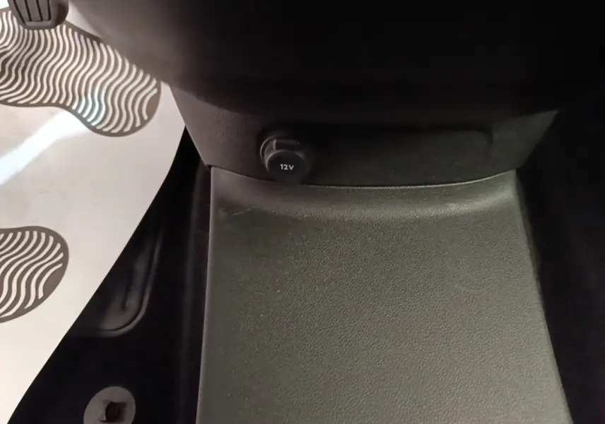 Vue rapprochée de la prise 12V noire située au bas de la console centrale du Citroën Berlingo blanc de 2020.