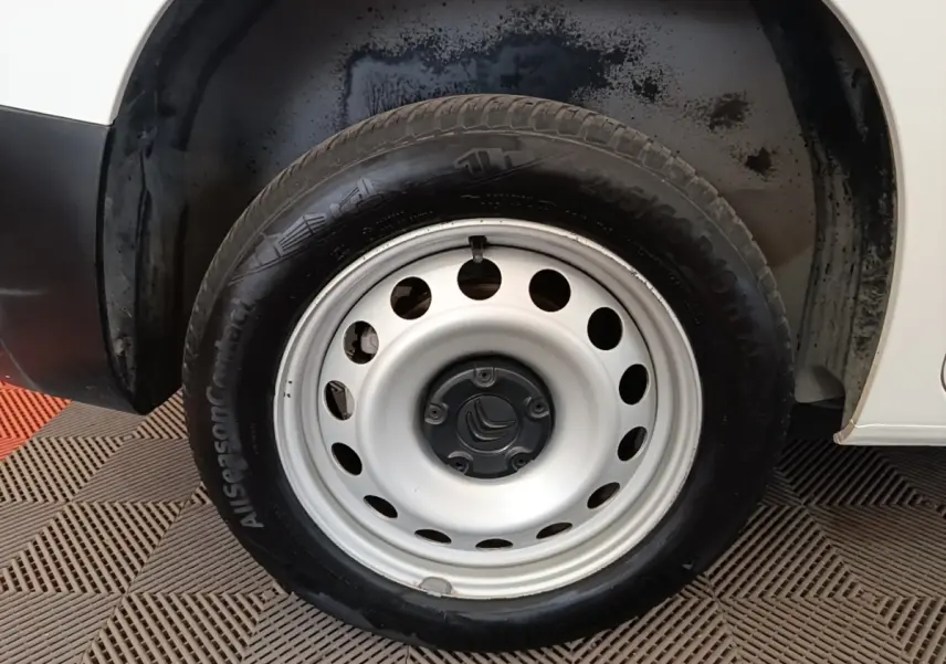 Gros plan sur la roue avant droite blanche d’un Citroën Berlingo 2020, jante acier avec logo Citroën central.