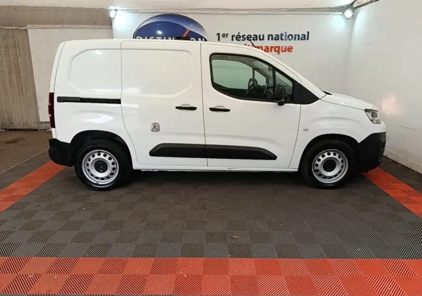 Vue latérale droite d’un utilitaire Citroën Berlingo blanc, avec portes latérales pleines et jantes acier simples.