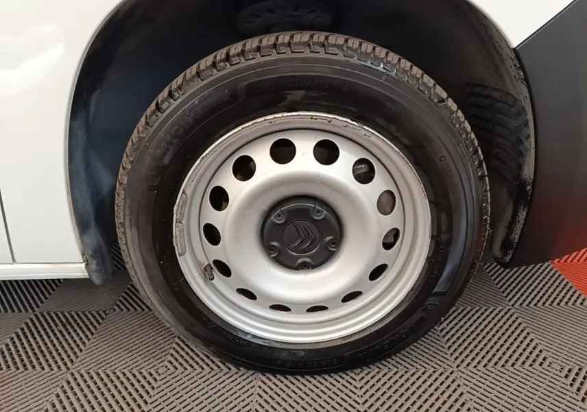 Gros plan sur la roue avant droite blanche d’un Citroën Berlingo 2020 avec jante acier et logo Citroën central.