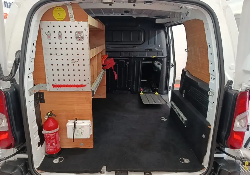 Vue arrière ouverte du Citroën Berlingo blanc avec aménagement bois et extincteur visible dans l’espace de chargement.