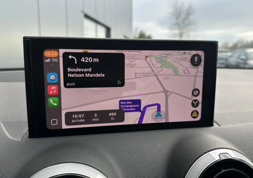 Vue intérieure du tableau de bord de l'Audi Q2 argent rosé, avec écran central affichant la navigation GPS.