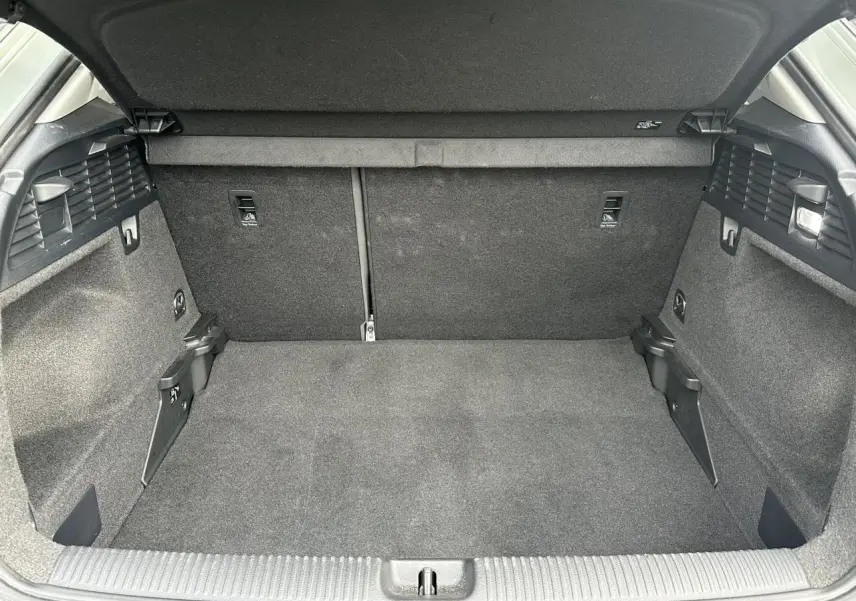 Vue intérieure du coffre spacieux et vide de l'Audi Q2 30 TFSI 110 S-Line 2024, avec revêtement gris foncé.
